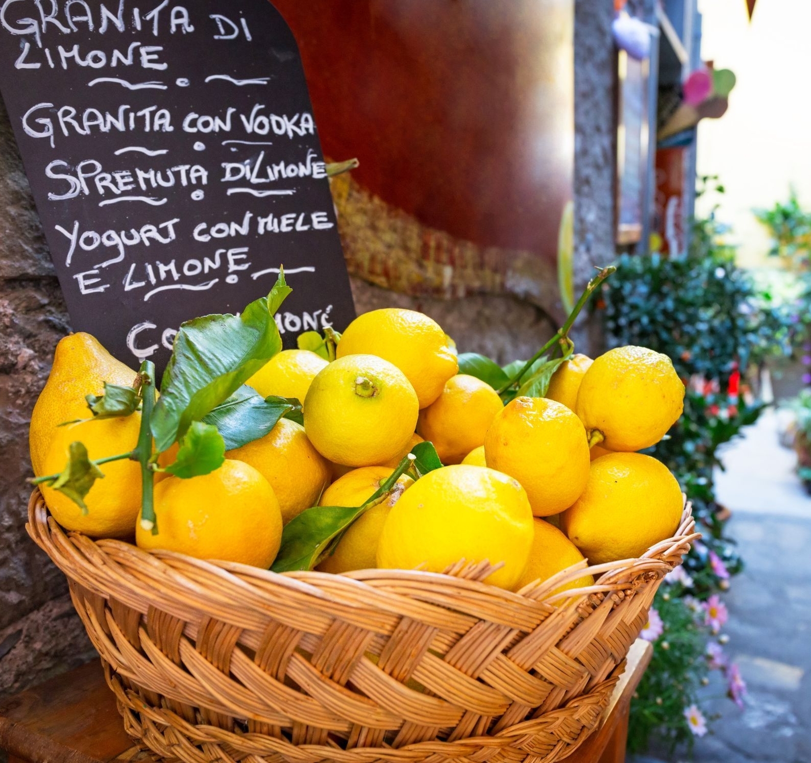 Cesta de mimbre con limones en una calle italiana