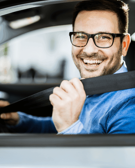 Smiling corporate executive with glasses fastening his seat belt