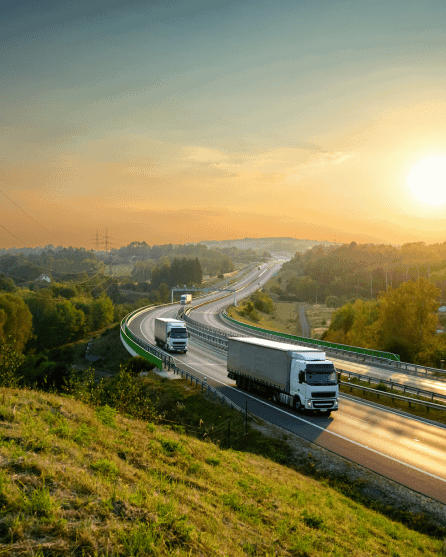 Trucks driving on the motorway with sunset
