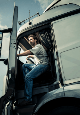 Truck driver wearing jeans opening truck door