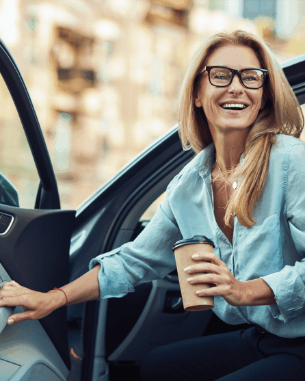 Smiling woman opening car door